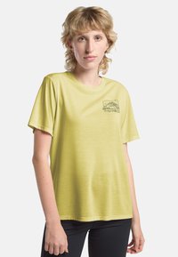 T-shirt a maniche corte di colore giallo chiaro realizzato in tessuto morbido, con una grafica di una montagna sul lato sinistro del petto in colore scuro.