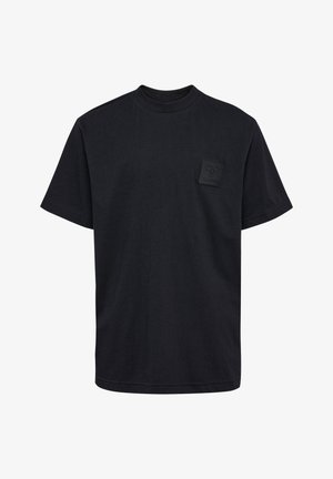 To børn står side om side iført matchende sorte t-shirts og bukser mod en ensfarvet baggrund.