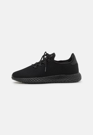 Schwarze Sportlaufschuhe aus strukturiertem Netzmaterial, mit einer abgerundeten Zehe, Schnürdesign und einer gemusterten Gummisohle.