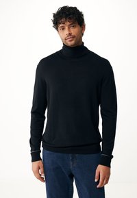 Zwarte coltrui gemaakt van zachte stof, slimfit ontwerp, geribde manchetten en zoom, gedragen met blauwe jeans, minimalistische stijl.