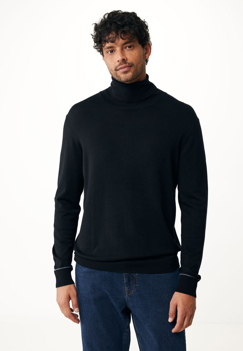 Zwarte coltrui gemaakt van zachte stof, slimfit ontwerp, geribde manchetten en zoom, gedragen met blauwe jeans, minimalistische stijl.