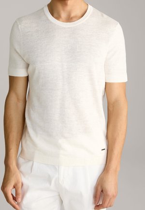 Maglione in maglia a maniche corte e colletto rotondo di un beige chiaro, realizzato in un tessuto testurizzato, con un piccolo logo vicino all'orlo.