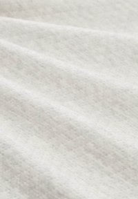 Witte textuurstof met een subtiele patroonontwerp, met een zachte en gladde oppervlakte. Het materiaal lijkt lichtgewicht en buigzaam.