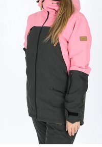 Veste résistante aux intempéries en noir et rose avec fermeture éclair, capuche ajustable, deux poches avant et écusson logo sur la manche.