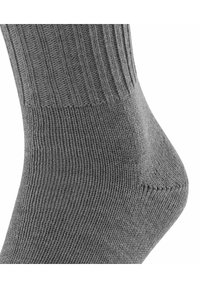 Calcetín gris acanalado con refuerzo en el talón, textura suave y puño elástico, diseñado para ofrecer comodidad y durabilidad.