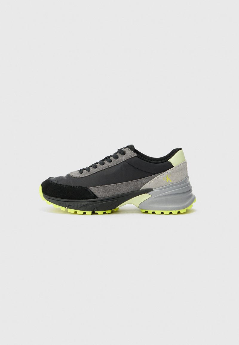 Sneaker met een zwart, grijs en neongroen ontwerp. Gemaakt van suede en synthetische materialen met een gestructureerde zool en een gevoerde kraag.