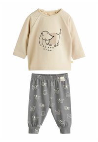 Beige Sweatshirt mit Hundegrafik und dem Text "HAPPY TIME", kombiniert mit grauen Jogginghosen mit dezenten Hundemuster und elastischem Bund.