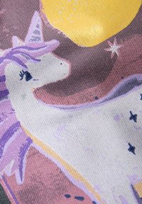 Ilustración de unicornio con melena morada, ojos cerrados, estrellas y un gran círculo amarillo sobre fondo de tela texturizada.
