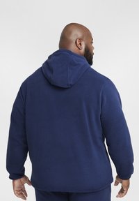 Felpa in pile blu navy con cappuccio, maniche lunghe e texture liscia, vista da dietro, che mostra un design pulito e minimale.