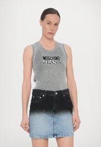 Pelēka ribota vairogu blūze ar tekstu "MOSCHINO JEANS", apvienota ar džinsu svārkiem ar ombre efektu no melna uz gaiši zilu.