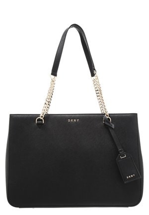 Bolso tote de cuero negro DKNY con cadena dorada y correas de cuero, con una etiqueta de marca colgando del asa.