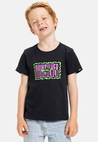 Camiseta de algodón negra con un vibrante logo gráfico en rosa y verde en el pecho, con un borde ondulado. Mangas cortas y corte casual.