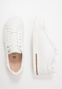 Baskets en cuir blanc avec une finition lisse, un design à lacets et un accent en liège texturé sur la semelle intermédiaire. Bout rond et semelle en caoutchouc.