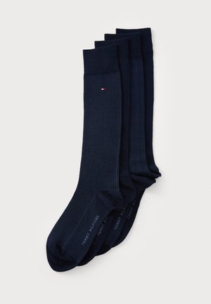 Dunkelblaue Socken im Paket mit drei Paaren, mit einem strukturierten Muster, gerippten Bündchen und einem gestickten Logo in kontrastierenden Farben.