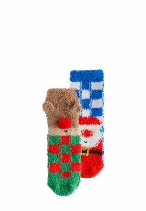 Flauschige Weihnachtssocken mit einem Rentierdesign und einem roten Pompon auf braunem Hintergrund sowie einem Weihnachtsmann-Gesicht auf blauem Hintergrund mit einem karierten rot-grünen Muster.