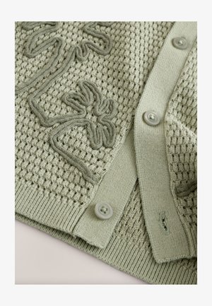 Cardigan lavorato a maglia color verde chiaro con motivo a rilievo, dettagli ricamati e grandi bottoni. Include rifiniture a coste sui bordi.