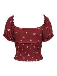 Blouse courte bordeaux avec manches bouffantes, taille smockée, petit motif floral blanc, encolure carrée et ourlet froncé.