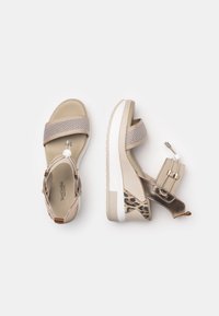 Beige platform sandals with mesh straps, smooth leather accents, leopard-print detail, and a textured sole. Quick-release buckle included.