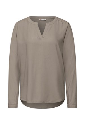Lange mouwen, taupe blouse met een V-hals. Heeft een zachte textuur en een gebogen zoom. Eenvoudig, onopvallend ontwerp dat geschikt is voor het lagen van kleding.