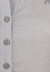 Maglione grigio chiaro con bottoni e un lavoro a maglia leggermente lucido e testurizzato. Presenta bottoni rotondi e piccoli embellishments.