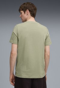 Oliven grøn bomulds t-shirt med klassisk rund hals. Korte ærmer, regulær pasform og glat tekstur. Ingen synlige designs eller mønstre.