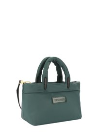 Bolso de nailon en tono teal con dos asas superiores, una correa de cuero desmontable y una etiqueta de logo negra en el frente. Textura suave con acentos mínimos.