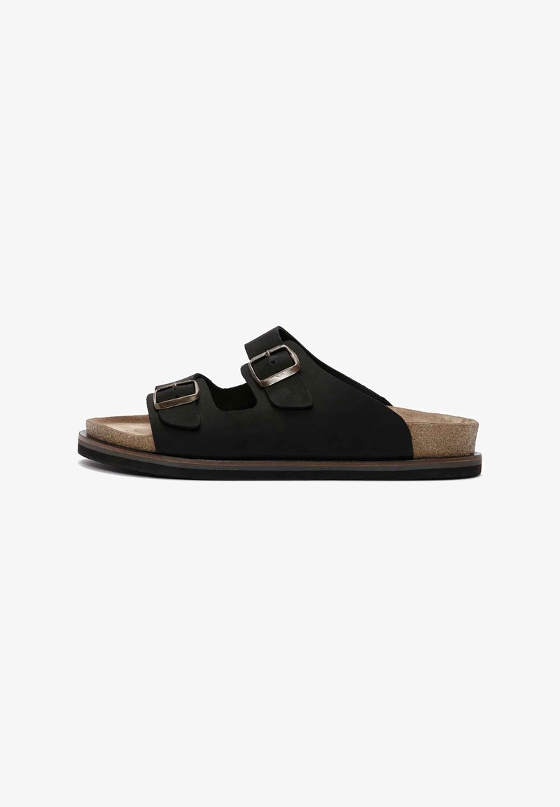 Czarne klapki na płaskiej podeszwie z dwoma regulowanymi klamrami, korkową wkładką oraz trwałą gumową podeszwą z brązowym akcentem.