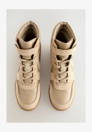Beige høje sneakers med en struktureret overdel i ruskind og læder, der har snørebåndslukning, en velcrolukning og en gummisål.