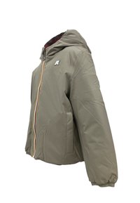 Giubbotto trapuntato color verde oliva chiaro con cappuccio. Presenta una cerniera frontale, tasche laterali e un piccolo logo sul petto. Tessuto liscio.