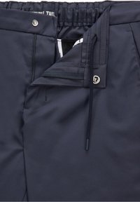 Navy blue twill pants with an elastic waistband, front zipper pocket, and drawstring closure. Smooth texture and minimal detailing.