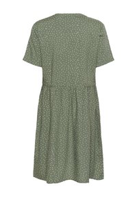 Grön klänning med vita prickar, korta ärmar, rund halsringning och elastisk midja, med en utställd kjoldesign och mjuk tygtextur.