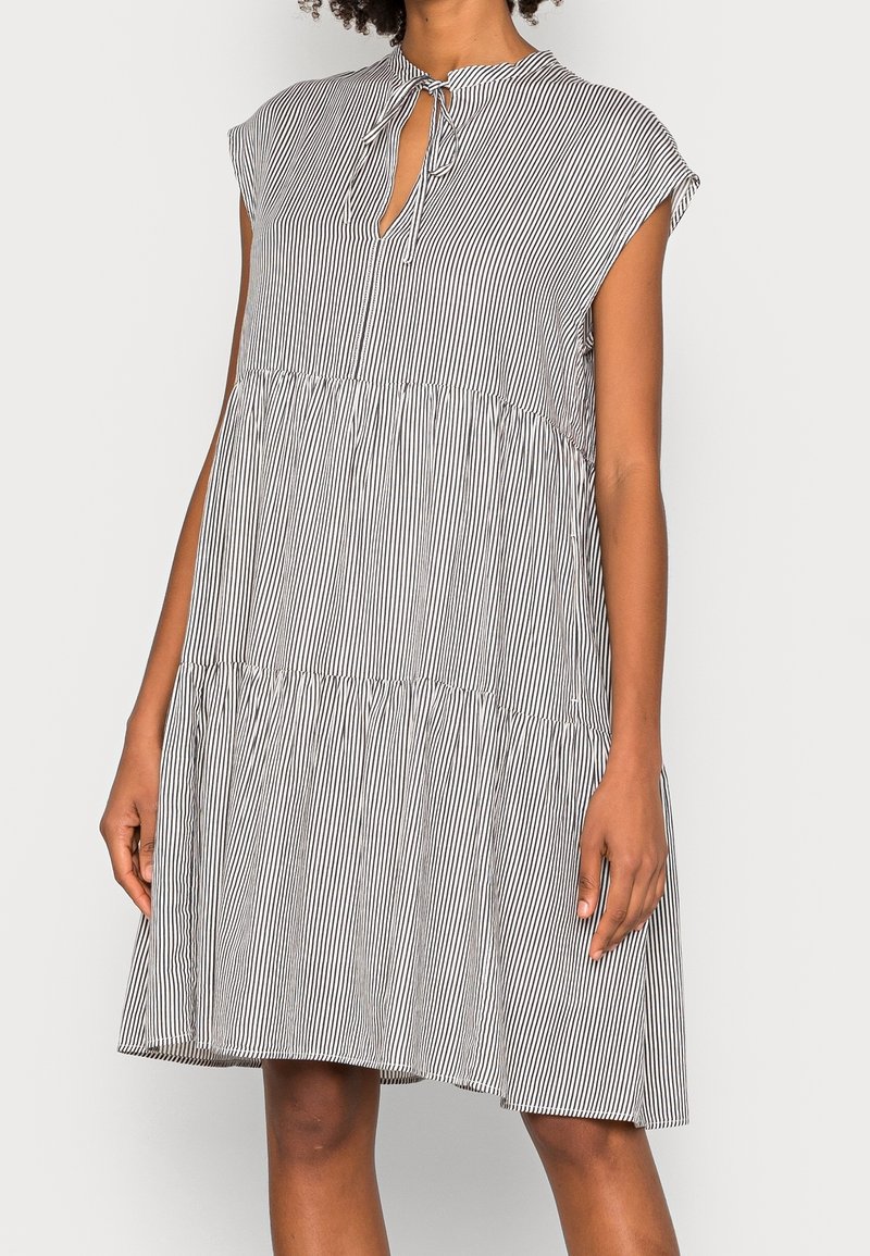 Zwart-wit gestreepte jurk met een ronde kraag, korte cap sleeves en een striksluiting bij de hals, met een tiered rok ontwerp.