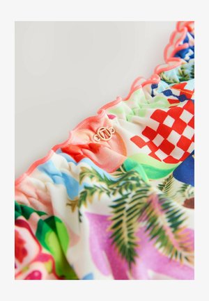 Top del costume da bagno multicolore con frange, caratterizzato da vivaci motivi floreali e geometrici, con bordi ondulati e un dettaglio della chiusura con logo in tono dorato.