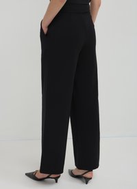 Calliope LUNGO BOTTONE - Pantaloni - nero