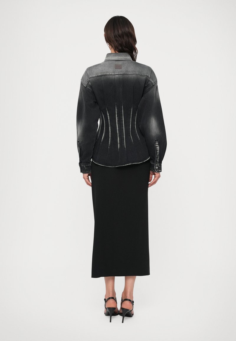 Svart denimjacka med strukturerad midja, blekt gradient och puffärmar, tillsammans med en lång svart kjol och strappy svarta klackar.