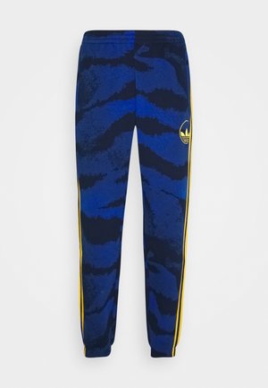 Blue and black patterned jogging pants with yellow side stripes and elastic cuffs, featuring a yellow Adidas logo on the right thigh.