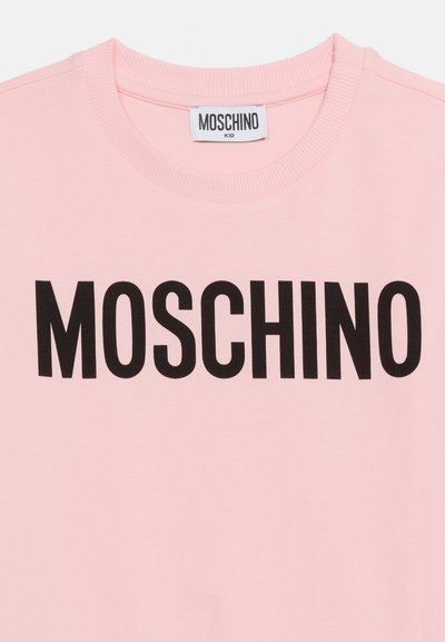 Ροζ παιδικό φούτερ με στρογγυλή λαιμόκοψη και έντονα μαύρα γράμματα "MOSCHINO" στο στήθος, με ετικέτα Moschino Kid μέσα στον γιακά.