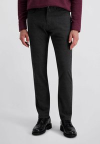 Donkergrijze broek met een gestructureerde afwerking, slim fit ontwerp, zijzakken en zwarte veterschoenen.