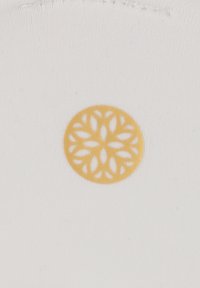 Tissu blanc avec un motif circulaire en dentelle jaune, présentant des formes de feuilles dans un motif symétrique au centre.