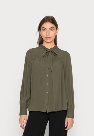 Blusa verde-oliva feita de um tecido leve, com um laço no colarinho, fecho de botões à frente, design pregueado e mangas longas.