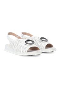 Hvide perforerede sandaler med åben tå og slingback-strop, der har to sorte cirkulære detaljer på overdelen. Flad gummisål.