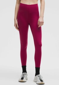 Dopasowane legginsy z wysokim stanem w intensywnym magencie, wykonane z elastycznego materiału, o gładkiej fakturze, z bezszwowym wykończeniem i długości do kostek.