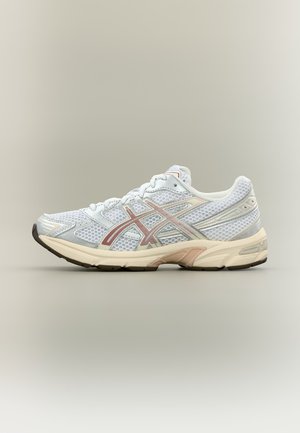 Zapatilla de correr blanca y beige con tejido de malla y logo Asics rosa claro en el lateral, mostrada de perfil izquierdo sobre fondo liso.