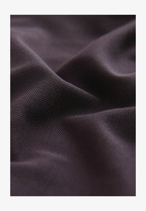 Donkerbruine textiel met een gestructureerd oppervlak, dat een subtiel weefpatroon en zachte plooien vertoont, wat de flexibele en lichte aard ervan benadrukt.