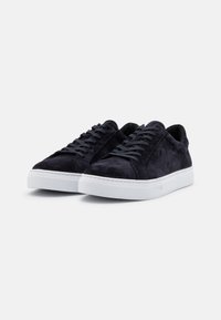Adidași bleumarin din suede cu talpă din cauciuc alb, vârf rotund și sistem de șireturi cu șase guri. Textură netedă cu detalii de cusătură minime.