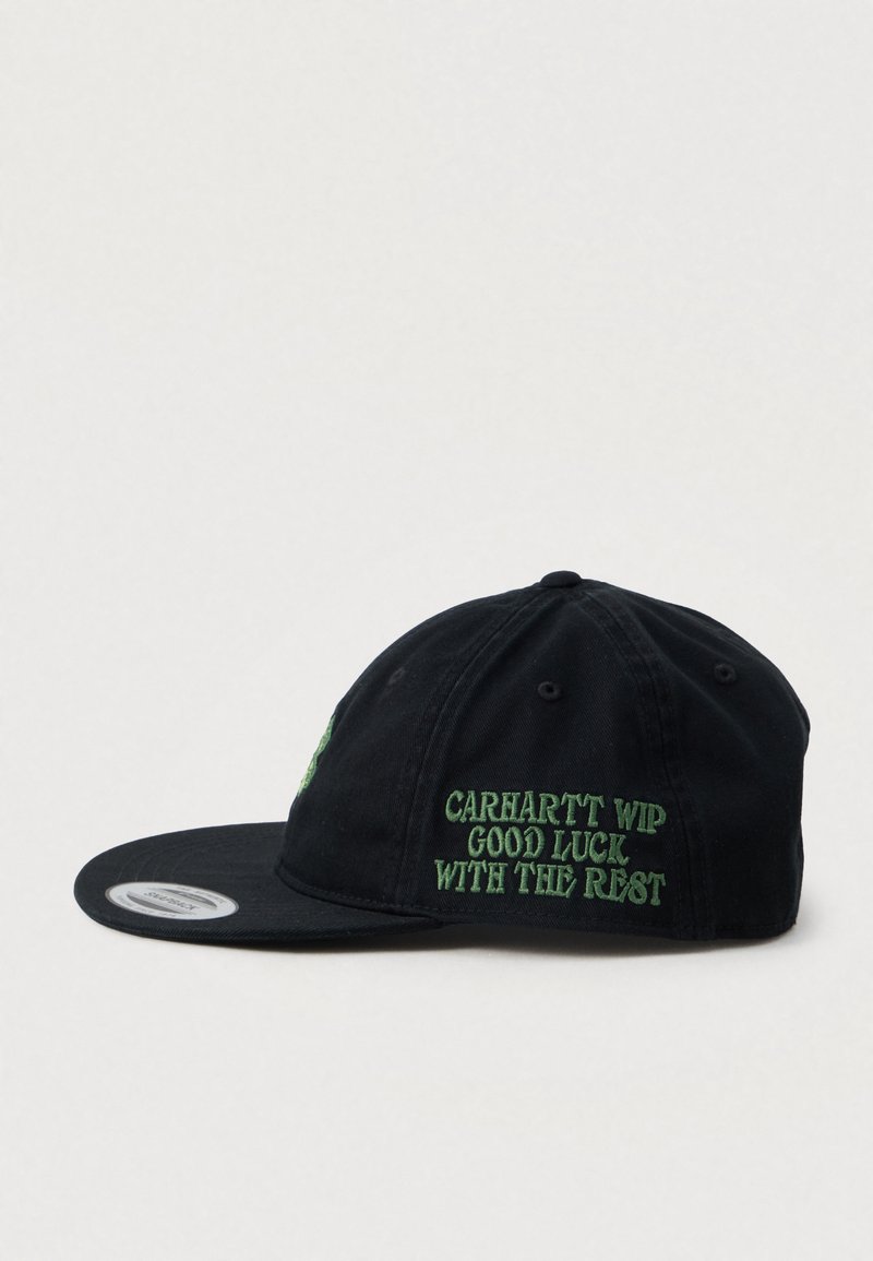 Schwarze Carhartt WIP Snapback-Cap mit grüner gestickter Schrift an der Seite, die "GUTES GLÜCK MIT DEM REST" lautet, und einem flachen Schirm.