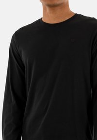 Zwarte lange mouwen T-shirt met een ronde hals, gemaakt van gladde katoenstof. Bevat een klein logo accent op de borst.