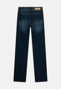 Jeans de mezclilla azul oscuro con corte recto, que cuentan con dos bolsillos traseros y una etiqueta de marca de cuero marrón en la cinturilla.