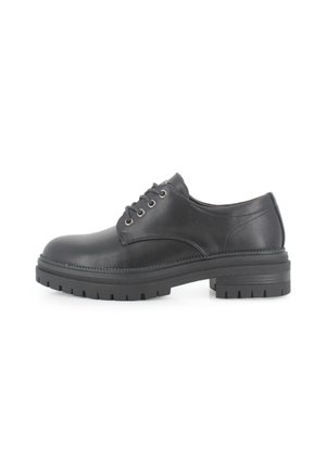 Zapato oxford de cuero negro con cierre de cordones, suela de goma resistente, punta redondeada y detalles de costura sutiles. Textura suave.