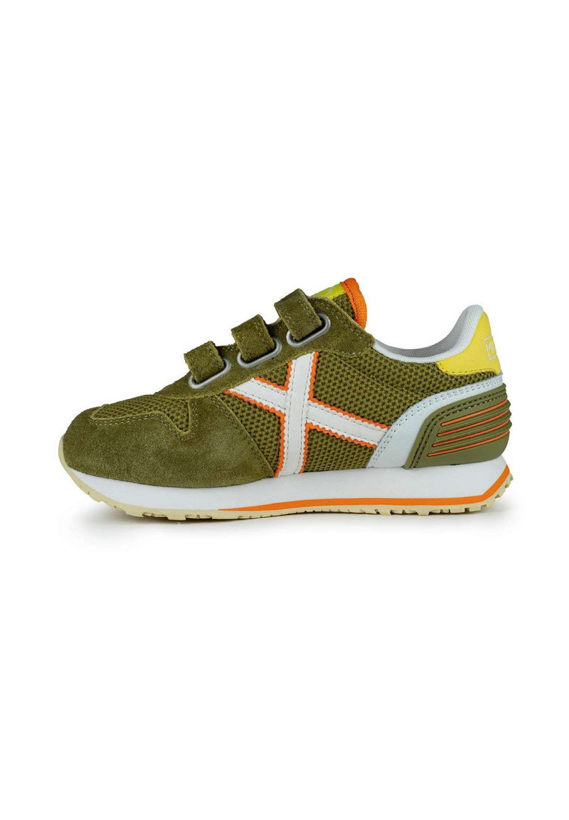 Zapatillas de ante verde y malla con correas de velcro, detalles en blanco y naranja, y una suela texturizada en blanco y naranja.
